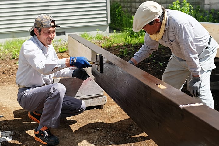 梁にオスモを塗る大工